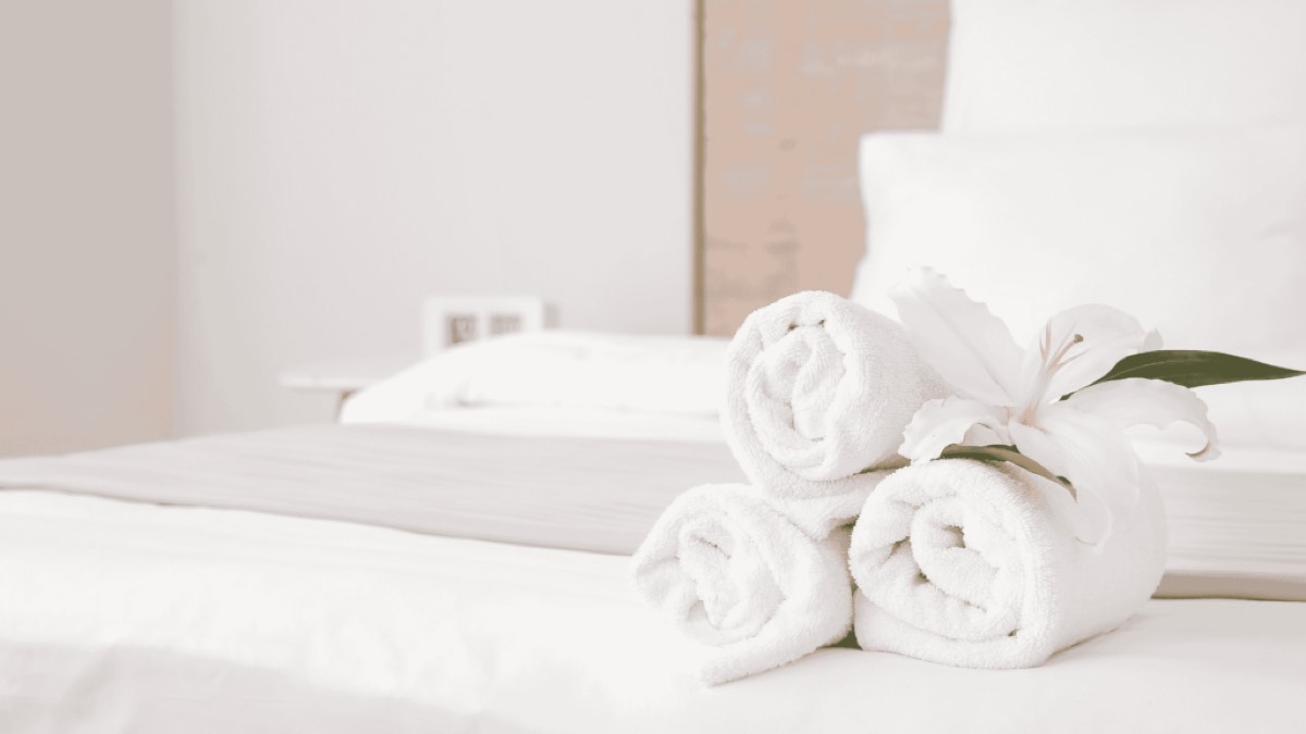 Cama preparada con toallas limpias para los huéspedes