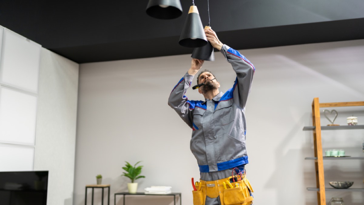 Técnico instalando una lámpara en un apartamento turístico