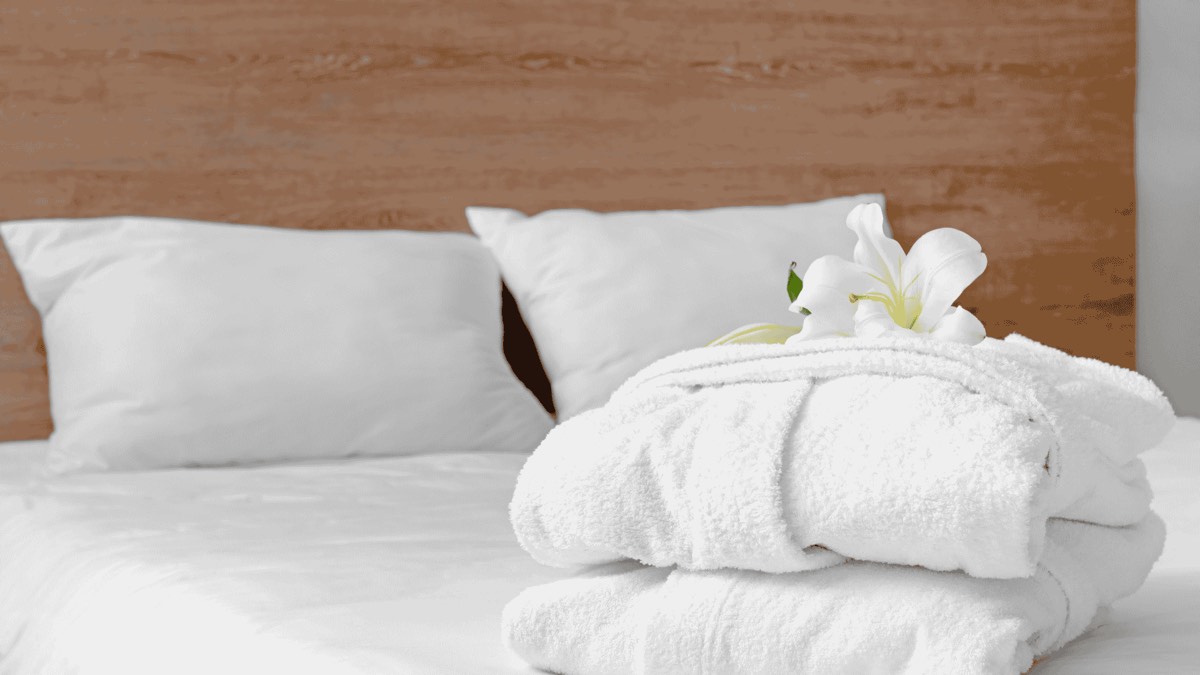 Ropa de cama y toallas limpias sobre una cama recién hecha