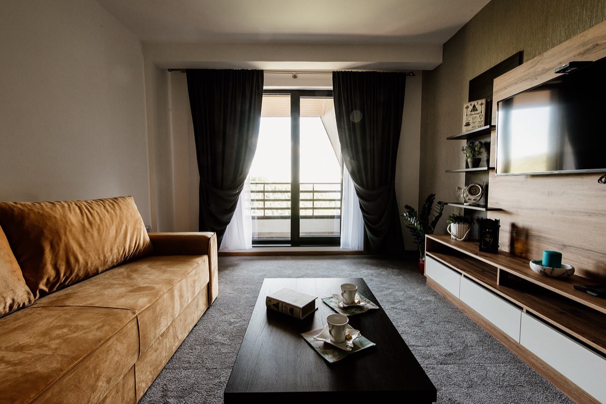Salón luminoso de un piso moderno, con sofá, mesa de centro y salida a la terraza