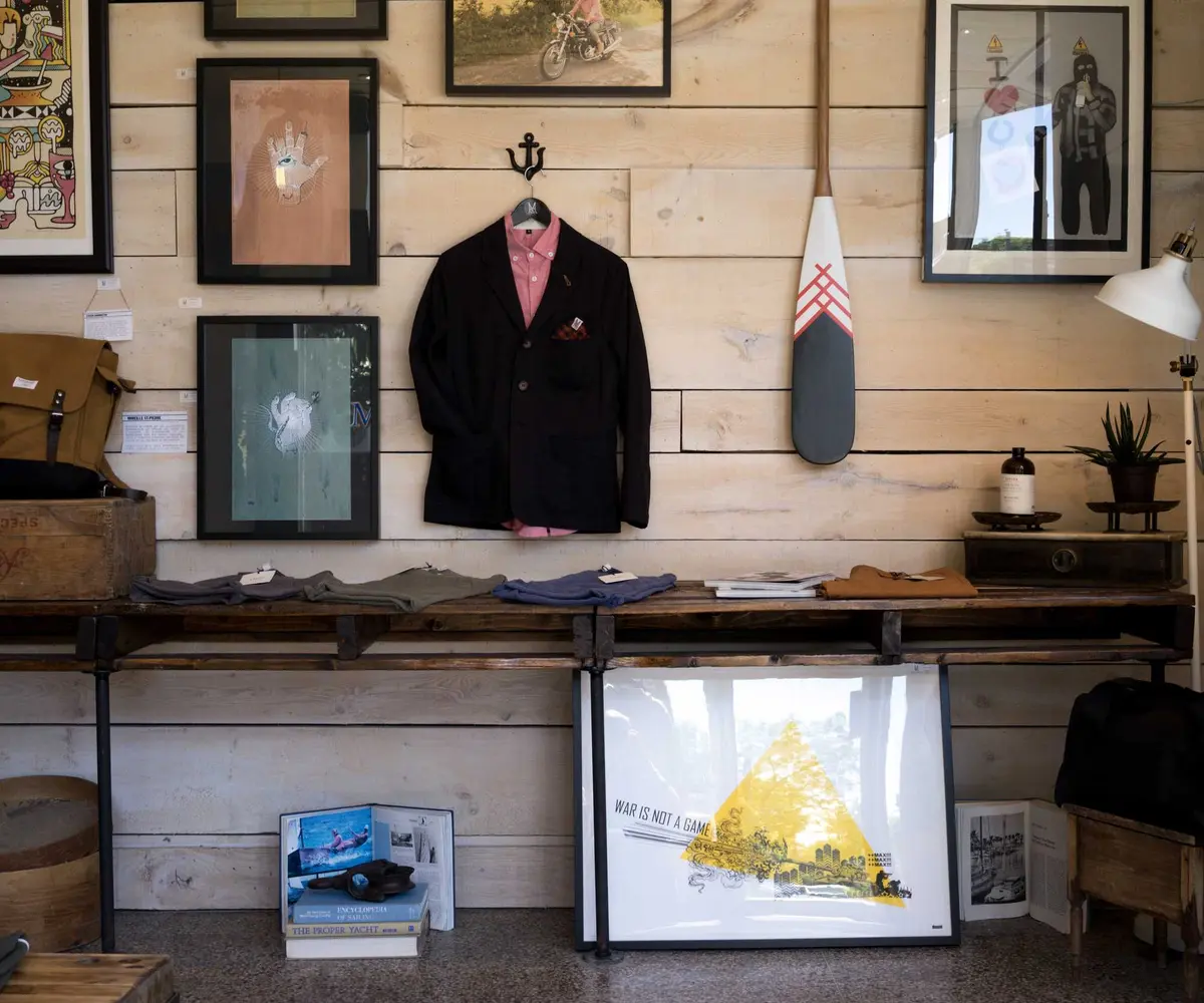 Pared de madera decorada con cuadros, una chaqueta colgada y mobiliario